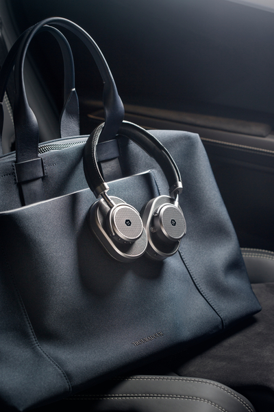 master and dynamic headphones in a black leather car on a black bag